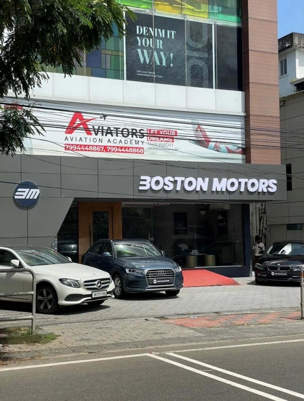The Boston Motors showroom on Mini Bypass, Calicut, with cars parked outside